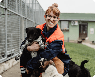 animal shelter worker hugging rescue dogs