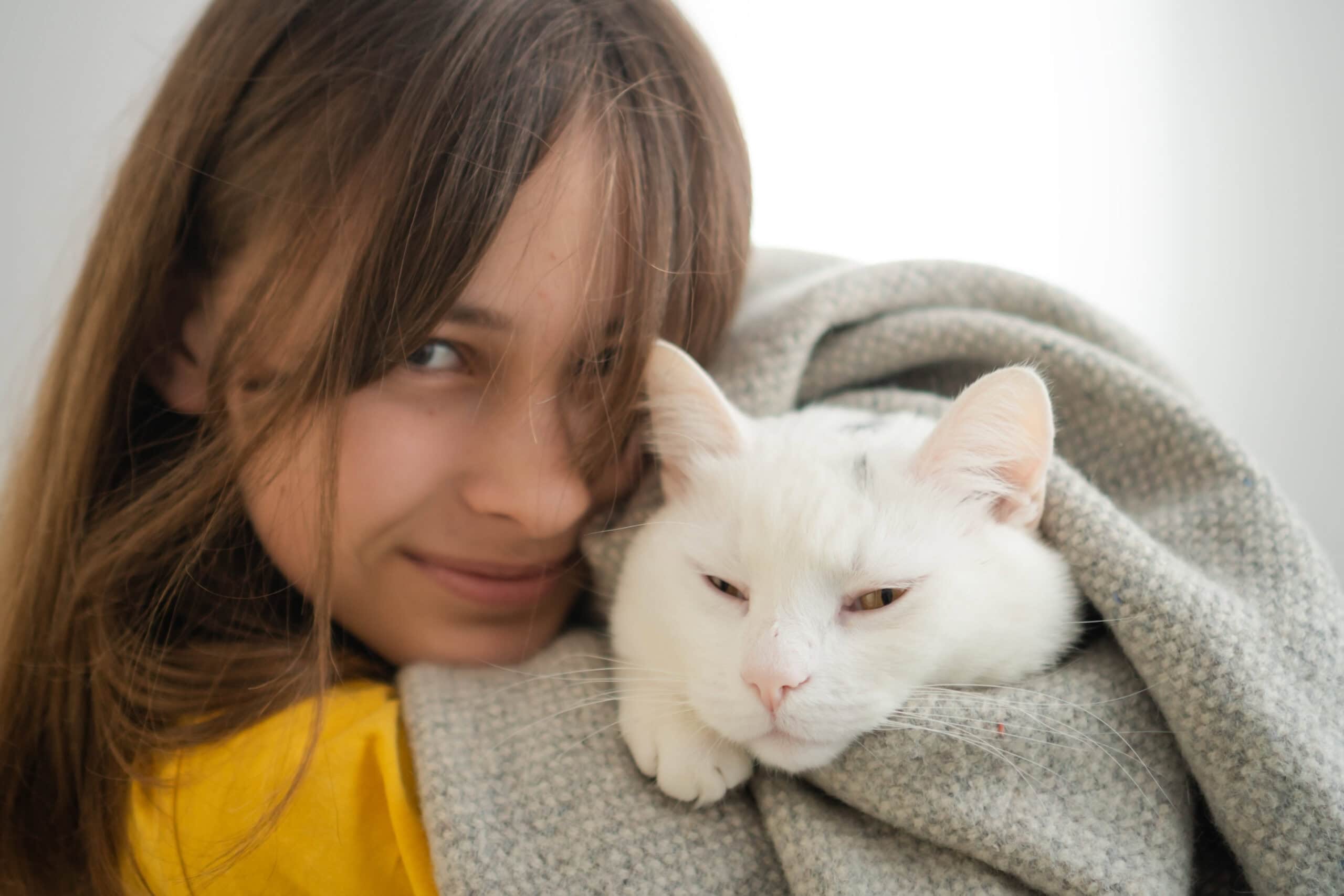White cat in girl loving arms
